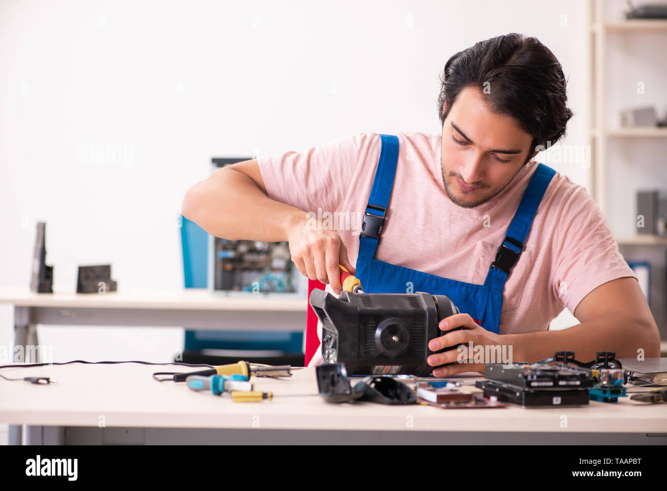 Young male contractor repairing computer Stock Photo