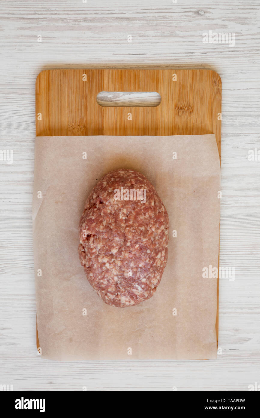 Fresh raw grass fed ground beef on a bamboo board, top view. Flat lay