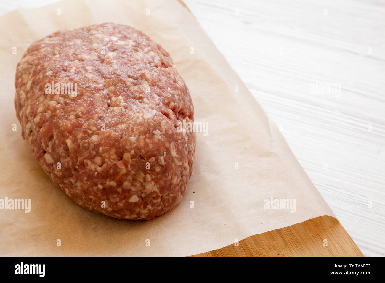 Fresh raw grass fed ground beef on a bamboo board, side view. Copy