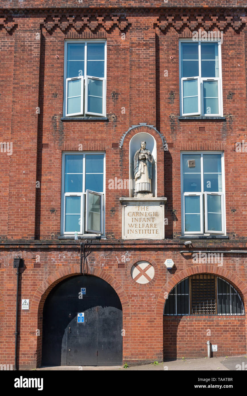Statue of woman inset into the wall of The Carnegie Infant Welfare Institute building in Hockley, Birmingham, UK, a mother and child's welfare centre Stock Photo