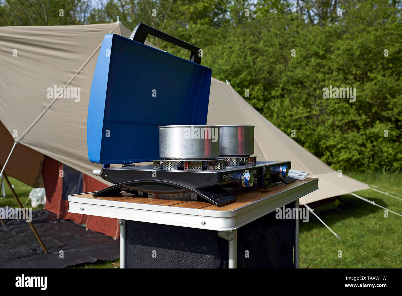 Gas cooker and cooker next to a tent of a camping site in nature Stock