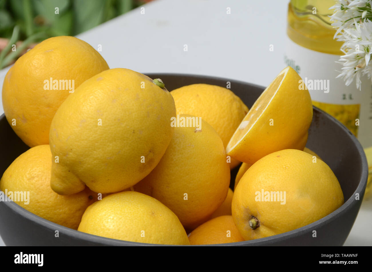 Closeup on bowl with yellow lemons in a table arrangement. Stock Photo