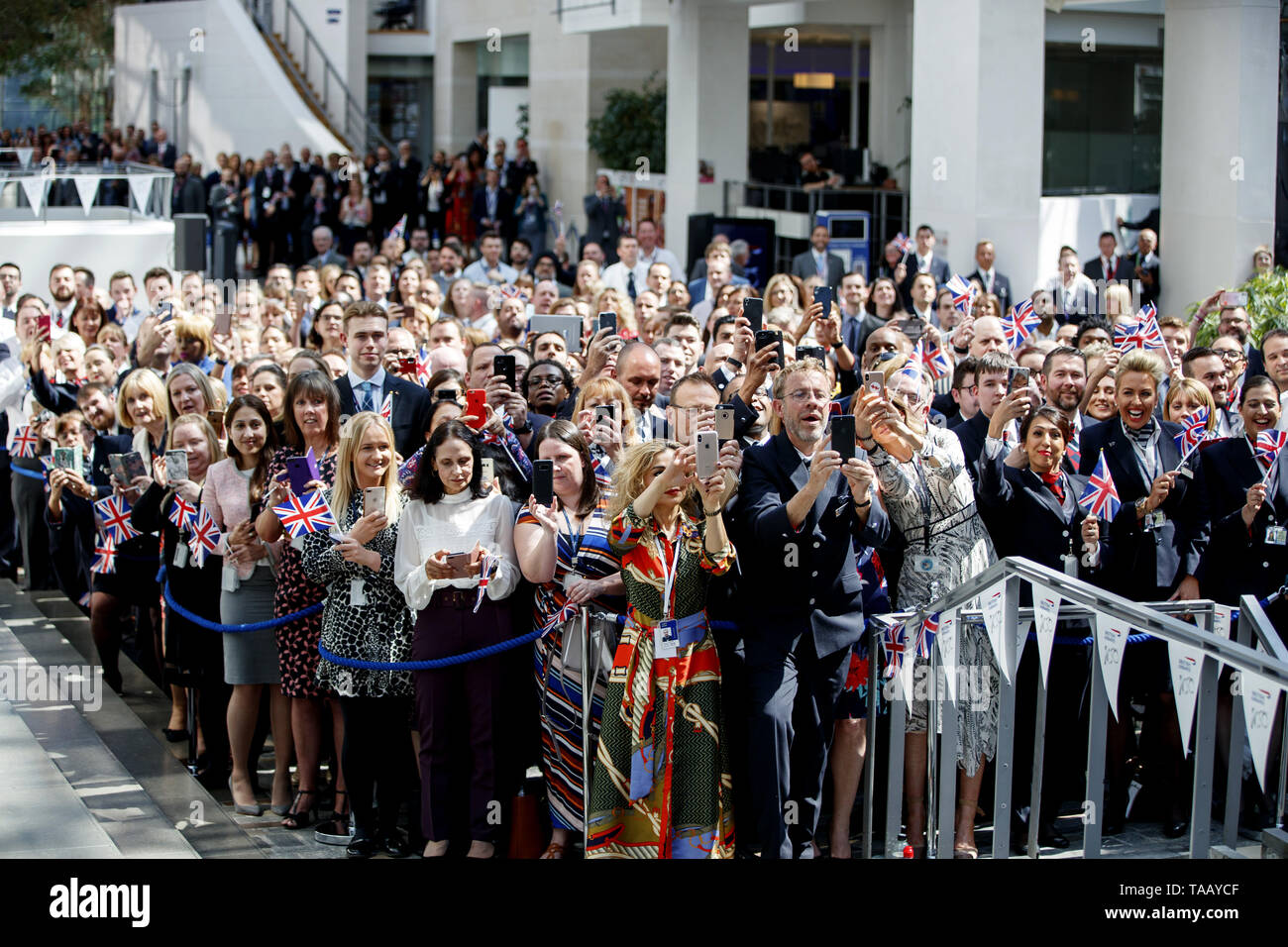 Staff wait to see Queen Elizabeth II during her visit to the headquarters of British Airways at Heathrow Airport, London, to mark their centenary year. Stock Photo