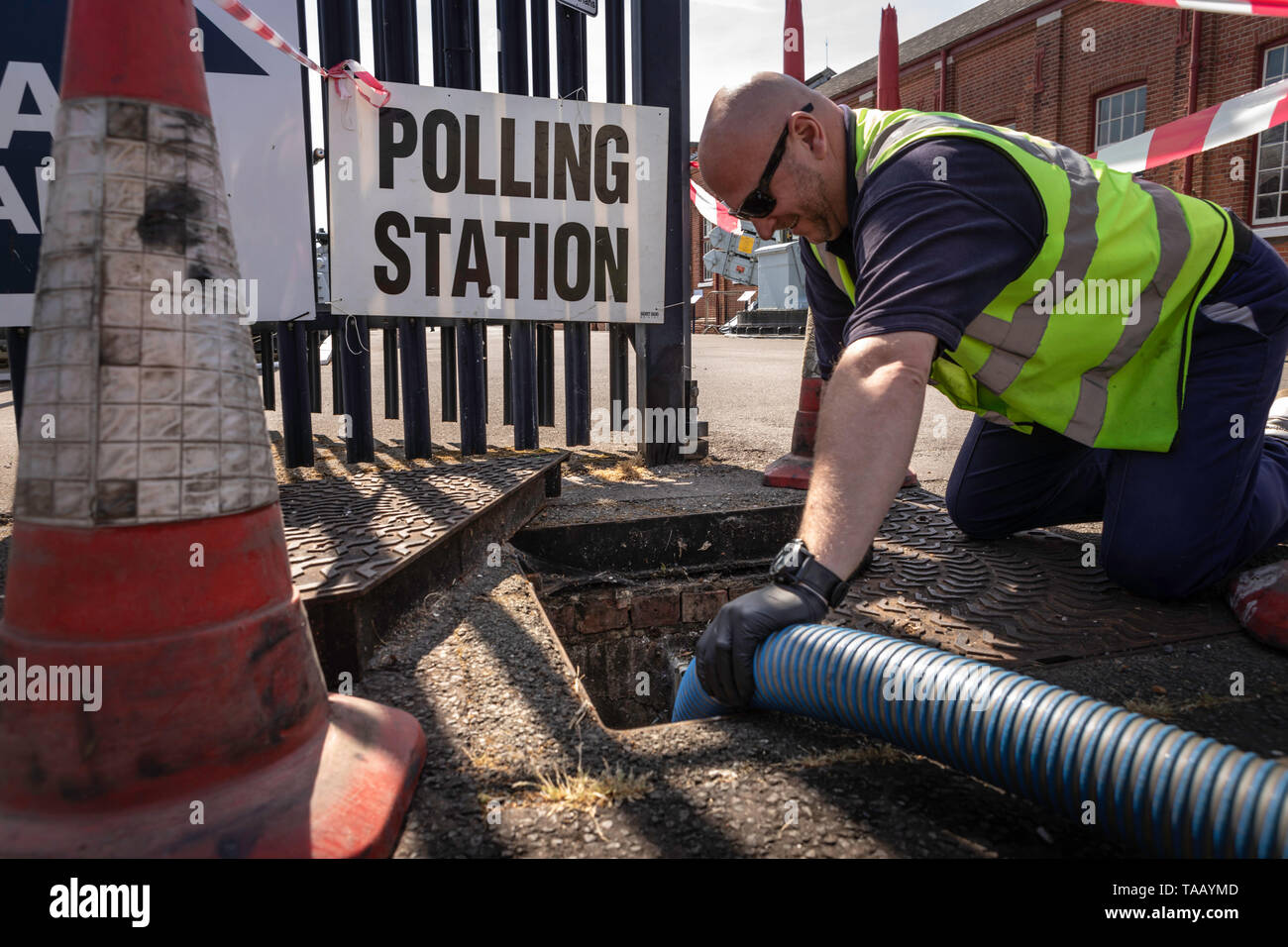 A sanitation engineer empties a cesspit outside a polling station in Gosport as voters head to the polls for the European Elections today. Stock Photo