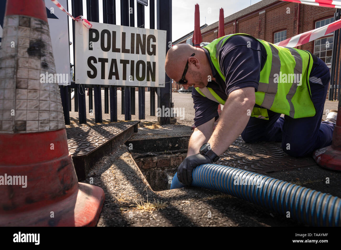 A sanitation engineer empties a cesspit outside a polling station in Gosport as voters head to the polls for the European Elections today. Stock Photo