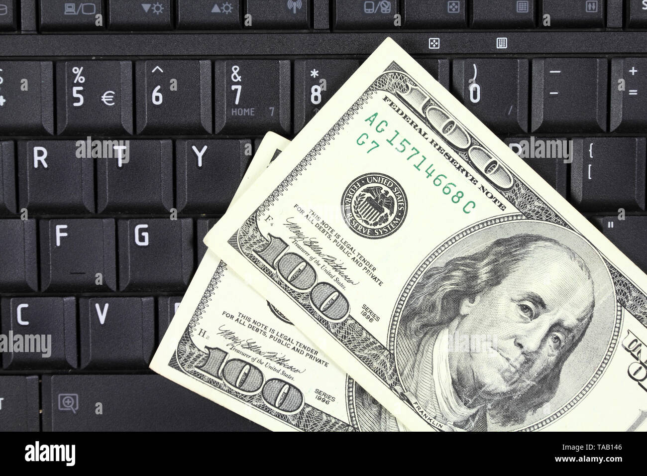 Online business - notebook keyboard and US 100 dollar bills Stock Photo