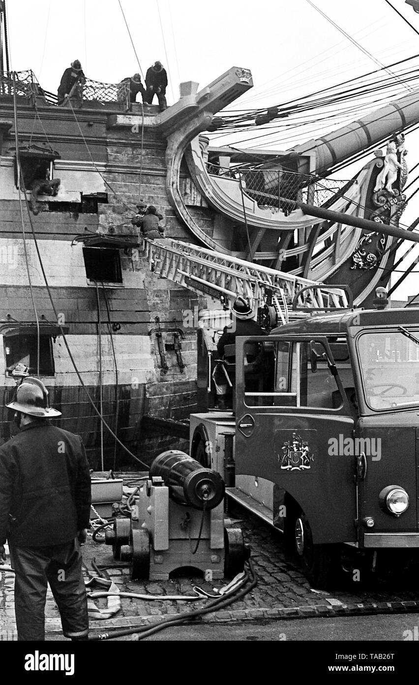 AJAXNETPHOTO. 27TH FEBRUARY, 1973. PORTSMOUTH,ENGLAND - FIRE IN THE HOLE! - MEMBERS OF PORTSMOUTH CITY FIRE BRIGADE STRUGGLE TO PUT OUT A FIRE IN ADMIRAL HORATIO NELSON'S FAMOUS TRAFALGAR FLAGSHIP H.M.S. VICTORY, STARTED WHILE RESTORERS WERE REMOVING OLD PAINT FROM INSIDE THE BOW SECTION.  PHOTO:JONATHAN EASTLAND/AJAX REF:357309 2 Stock Photo