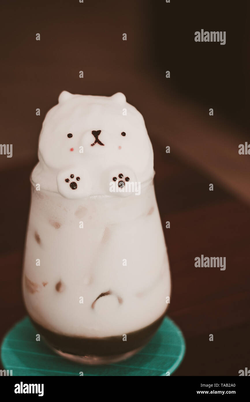 cafe latte art bear made by barista with milk foam and espresso in a