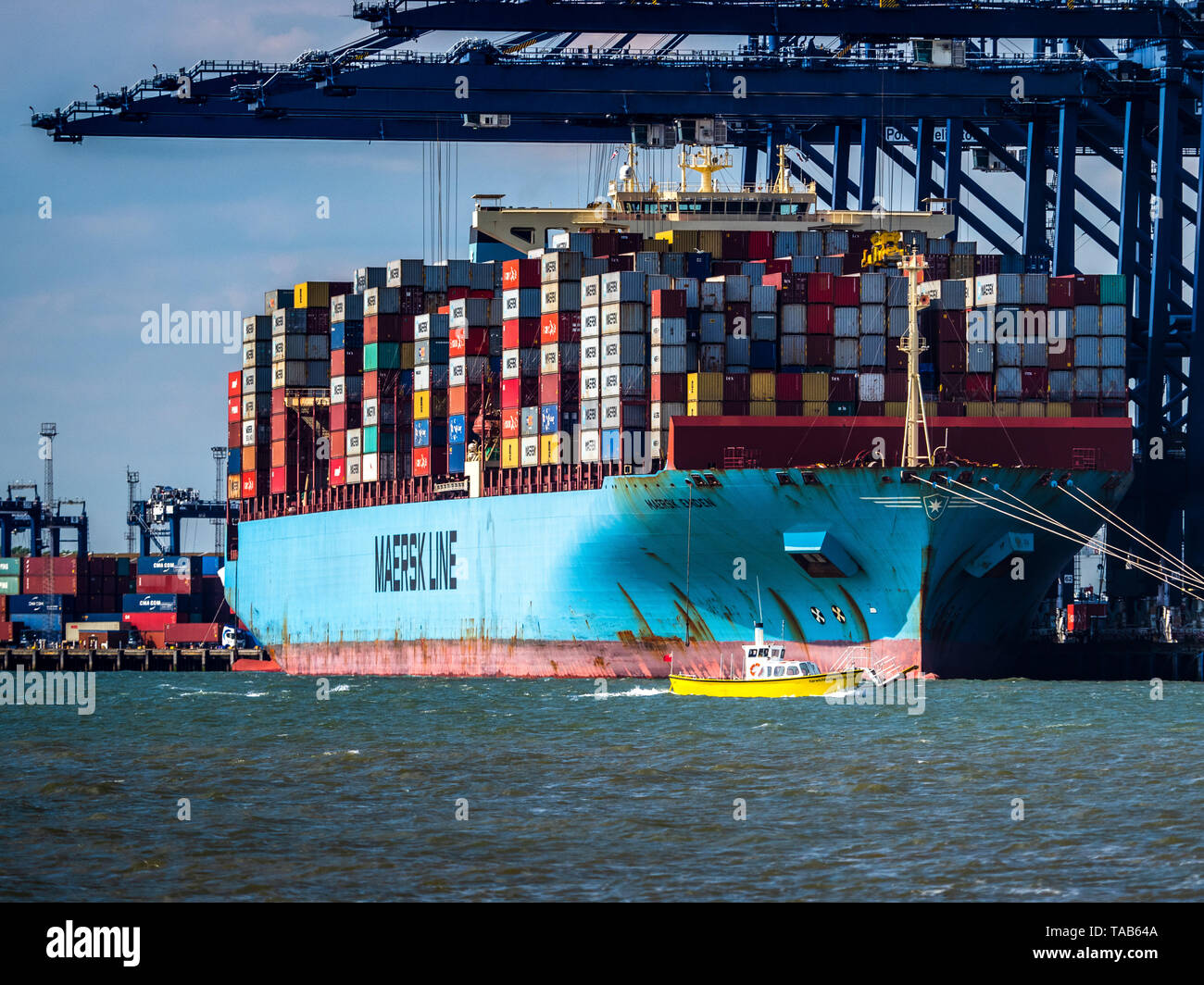 Maersk Line - British Trade - The Harwich Harbour Ferry is dwarfed as shipping containers are unloaded from a Maersk Container ship at Felixstowe Port Stock Photo