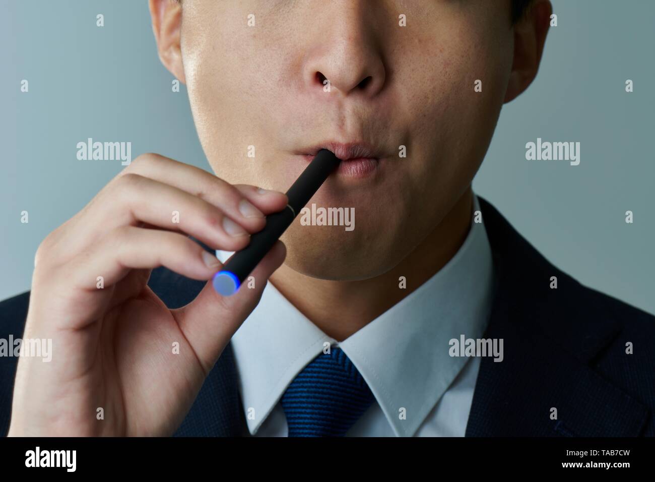 Young Japanese man smoking electronic cigarette Stock Photo