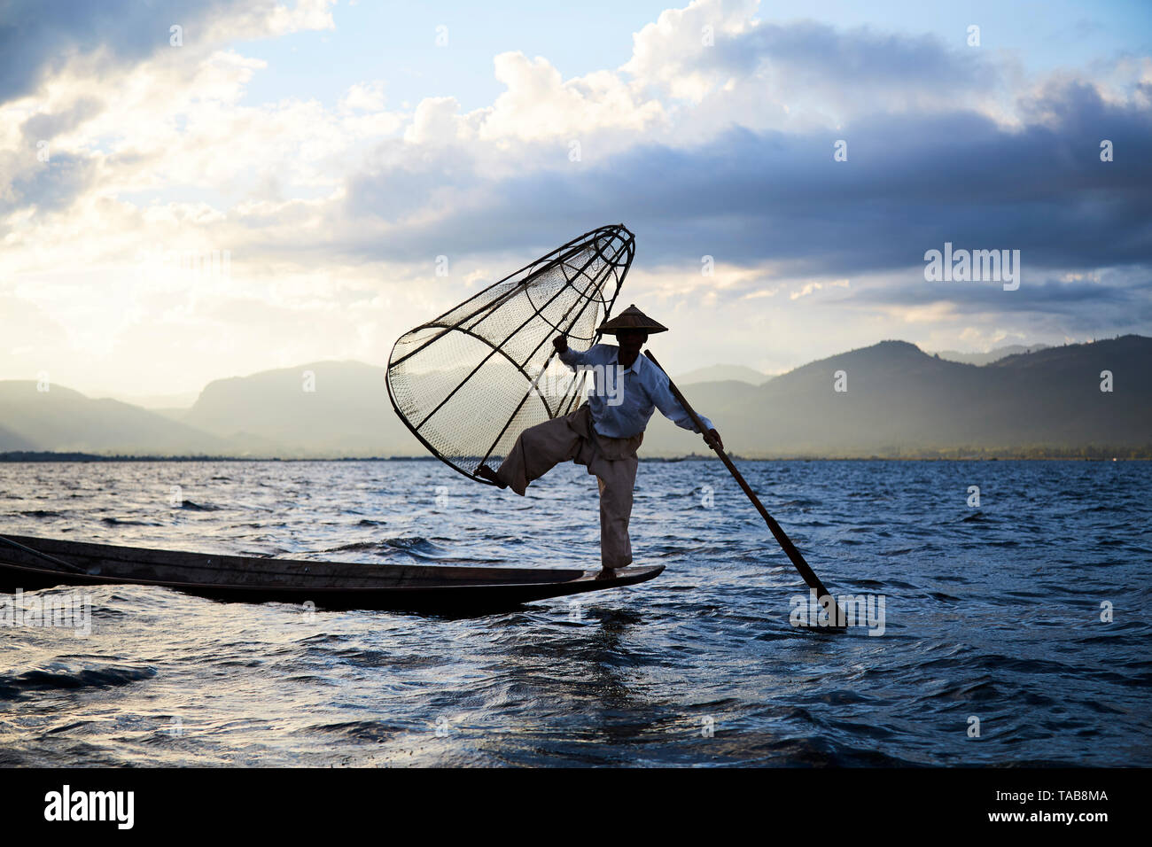 Traditional fisherman with net on boat on Inle Lake, Myanmar. Stock Photo