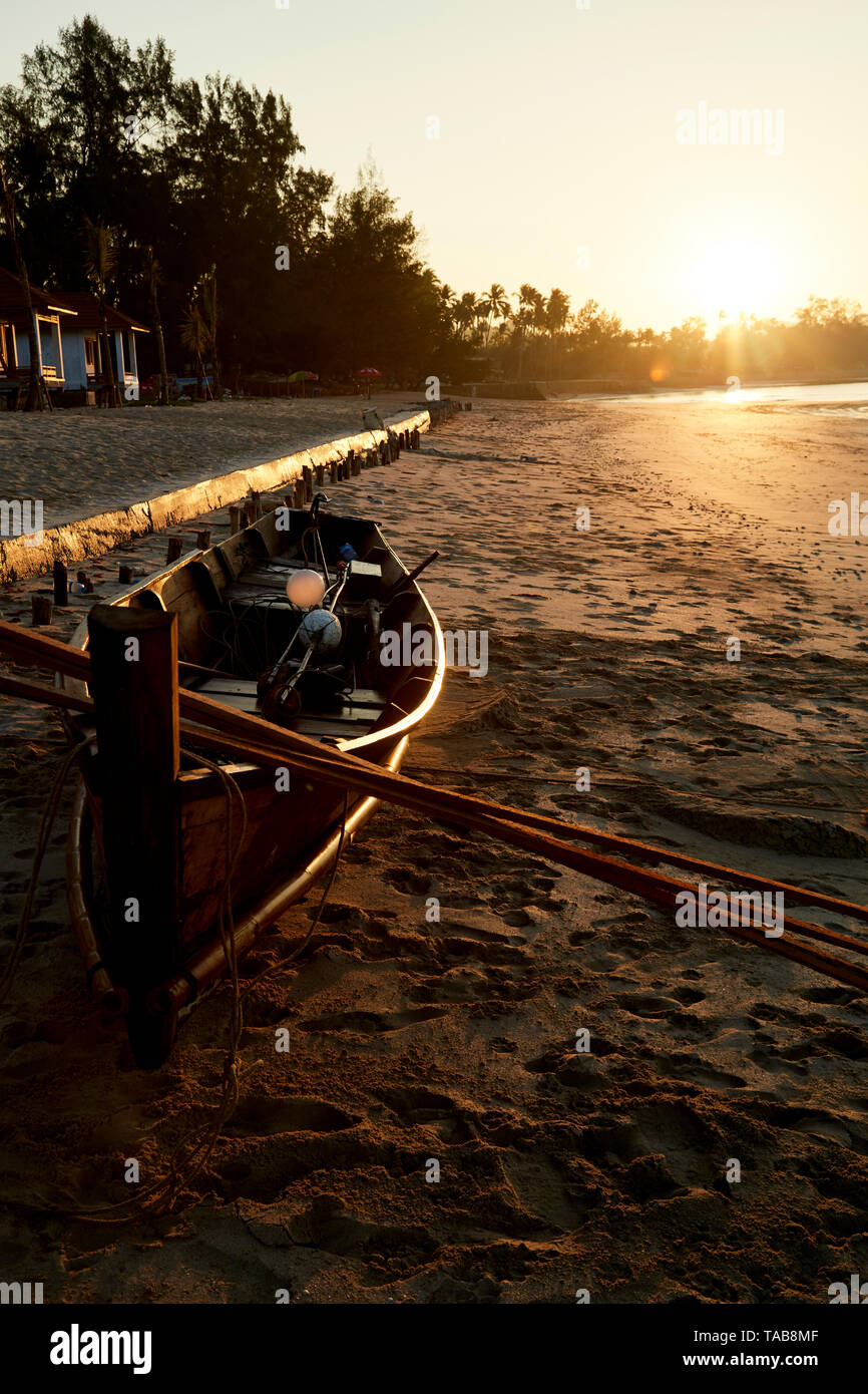 Small fishing boat on beach at sunrise in Ngapali, Myanmar in Southeast Asia. Stock Photo