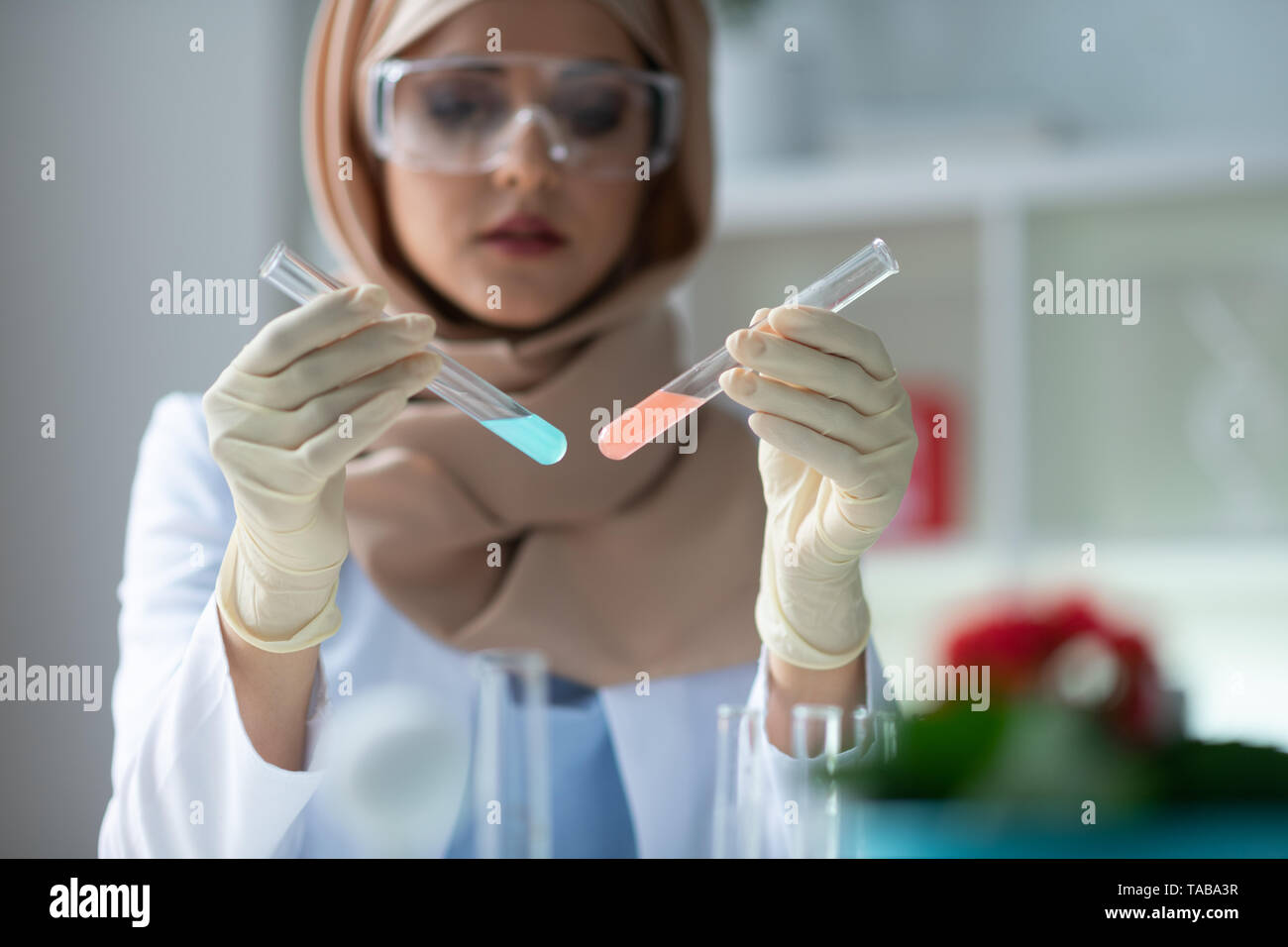 Pink And Blue Close Up Of Female Chemist Holding Test Tubes With Pink And Blue Chemical Agents 0936