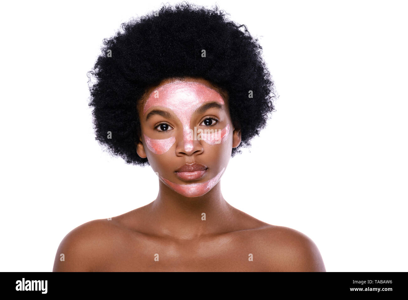 Young African woman with a purifying mask on her face over white background Stock Photo