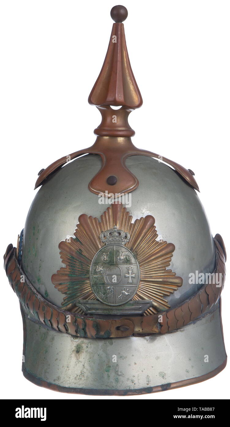 An Imperial German helmet M 1850/66 for an officer of the Mecklenburg Cuirassiers Tall silver lobster tail body with gold trim, trim and body have been repaired in several places, front visor is missing leather lining, back lobster tail has dark blue velvet lining, leather sweatband and silk lining are missing, officer Mecklenburg silver coat of arms on gold star front plate attached by three large brass splints, one splint is missing. Fluted spike, cross base and convex chinstraps have heavy golden patina over officer gilt. Extra holes for side , Additional-Rights-Clearance-Info-Not-Available Stock Photo