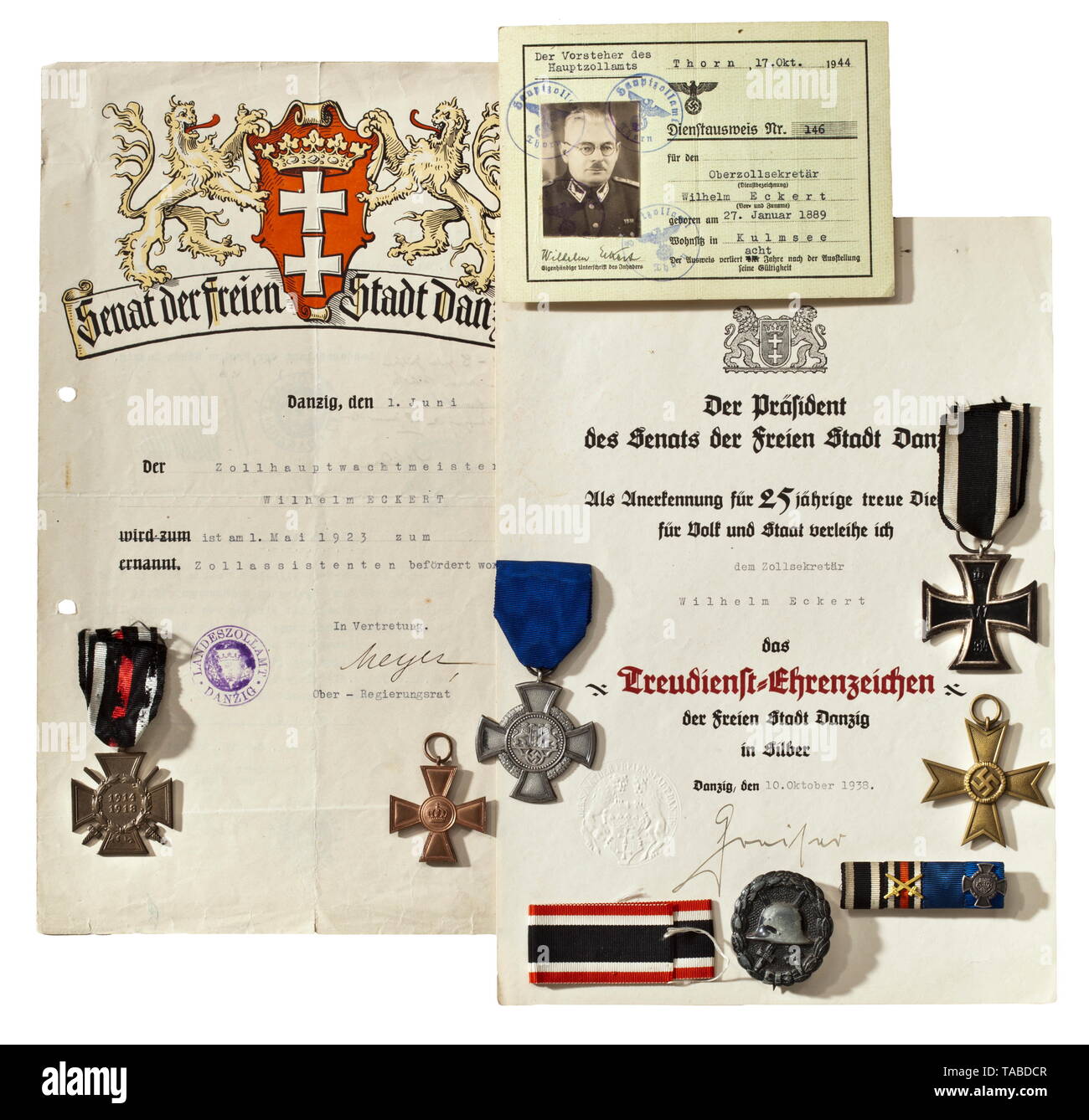 Free City of Danzig - a collection of awards and documents belonging to Wilhelm Eckert, customs secretary (Faithful Service Decoration) The original issue of the Danzig Faithful Service Decoration in Silver, made of silver laminated cupal with polished edges, on the ribbon, with safety pin fastener. Width 45.7 mm. Weight including ribbon 22.8 g. Also, the A 4-sized award document, printed in colour on carton with the blind embossed seal of the Senate of the Free City of Danzig. Issued 10 October 1938 to 'Zollsekretär Wilhelm Eckert' and bearing the original signature of Sen, Editorial-Use-Only Stock Photo