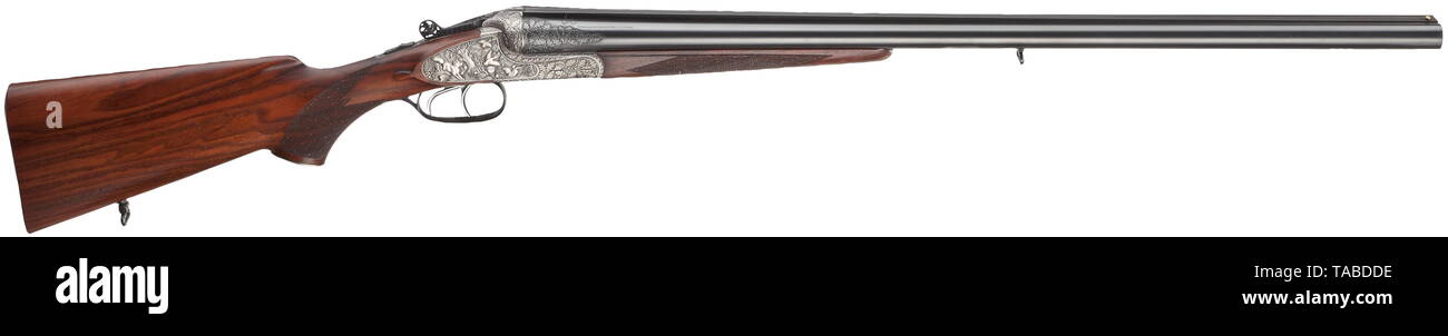 A double-barrelled shotgun, Merkel Luxus, former IWA exhibition piece Calibre 12/70, no. 770401. Smoothbore barrels, length 70.8 cm. German proof mark. Full-choke and cylinder bore. Wide, guilloched barrel rails. Brass bead front sight. Barrels burnished in black, the area of the roots of the barrel carved with an oak leaf décor. System with double underbolts and a Greener top fastener. Side locks. Lateral cocking indicator. Double trigger. Action case grey, engraved with oak leaves. The lock plates animal scenes inlaid in silver. on the left two, Additional-Rights-Clearance-Info-Not-Available Stock Photo