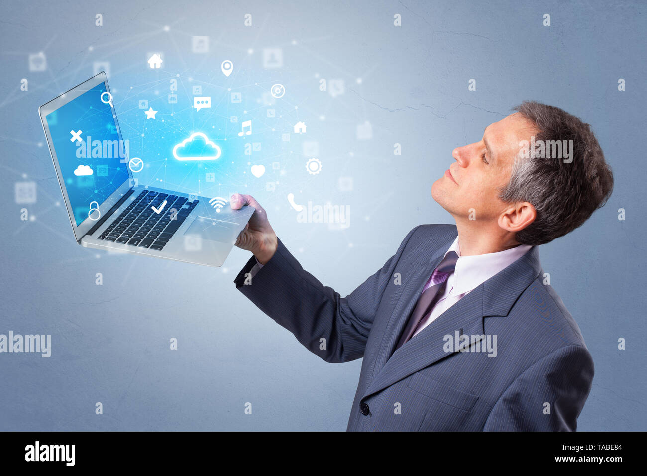 Man holding laptop projecting notifications, symbols and information based on cloud technology system  Stock Photo