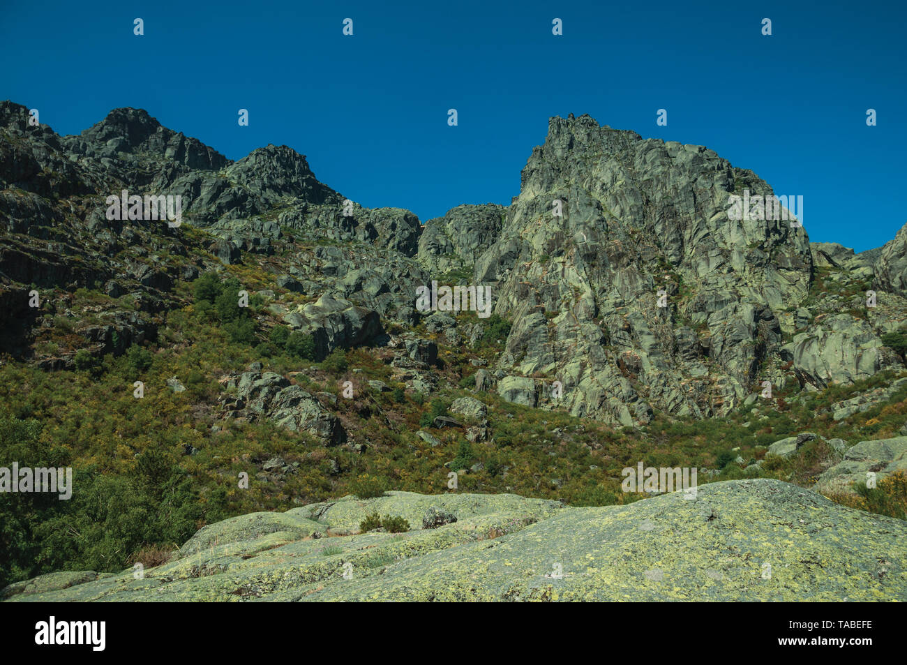 Mountainous landscape with rocky cliffs covered by bushes at the highlands of Serra da Estrela. The highest mountain range in continental Portugal. Stock Photo