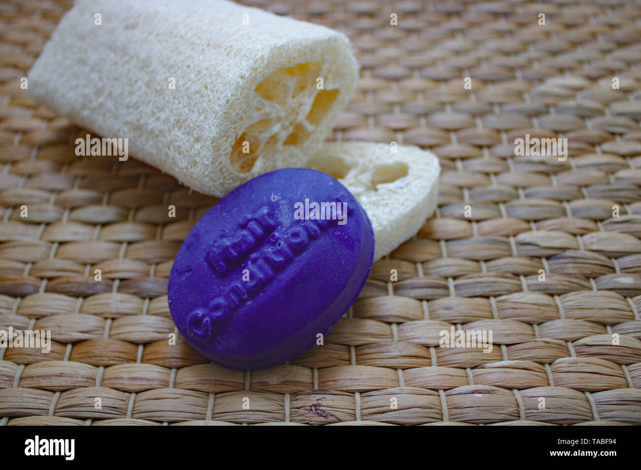 Natural Conditioner Bar leaning on natural loofah sponge Stock Photo