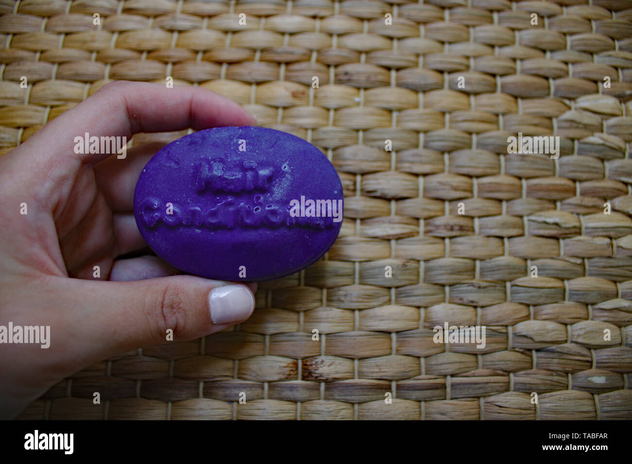 Woman holding purple conditioner bar. Plastic Alternative Stock Photo