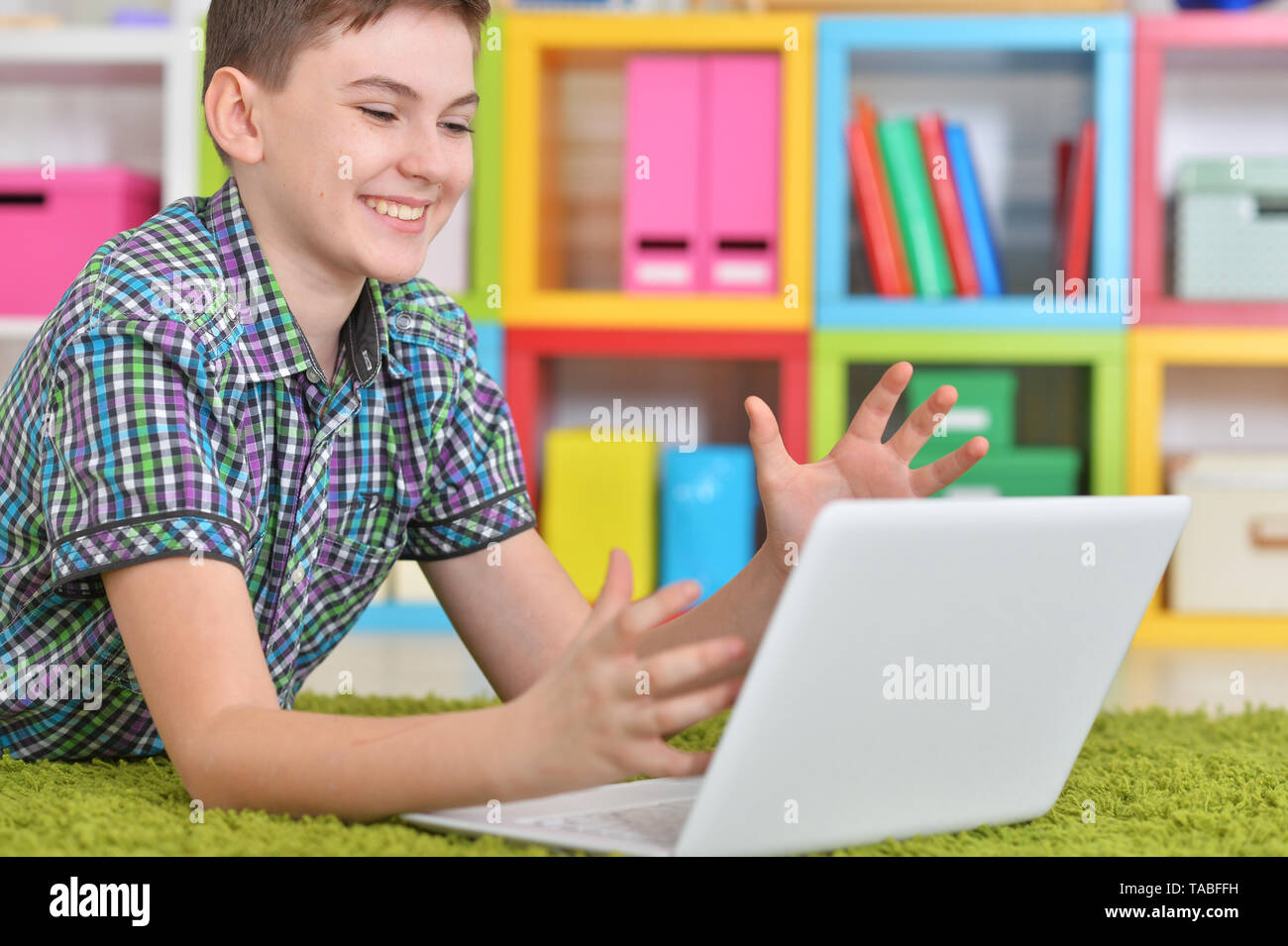 Little boy using laptop while lying on floor Stock Photo - Alamy