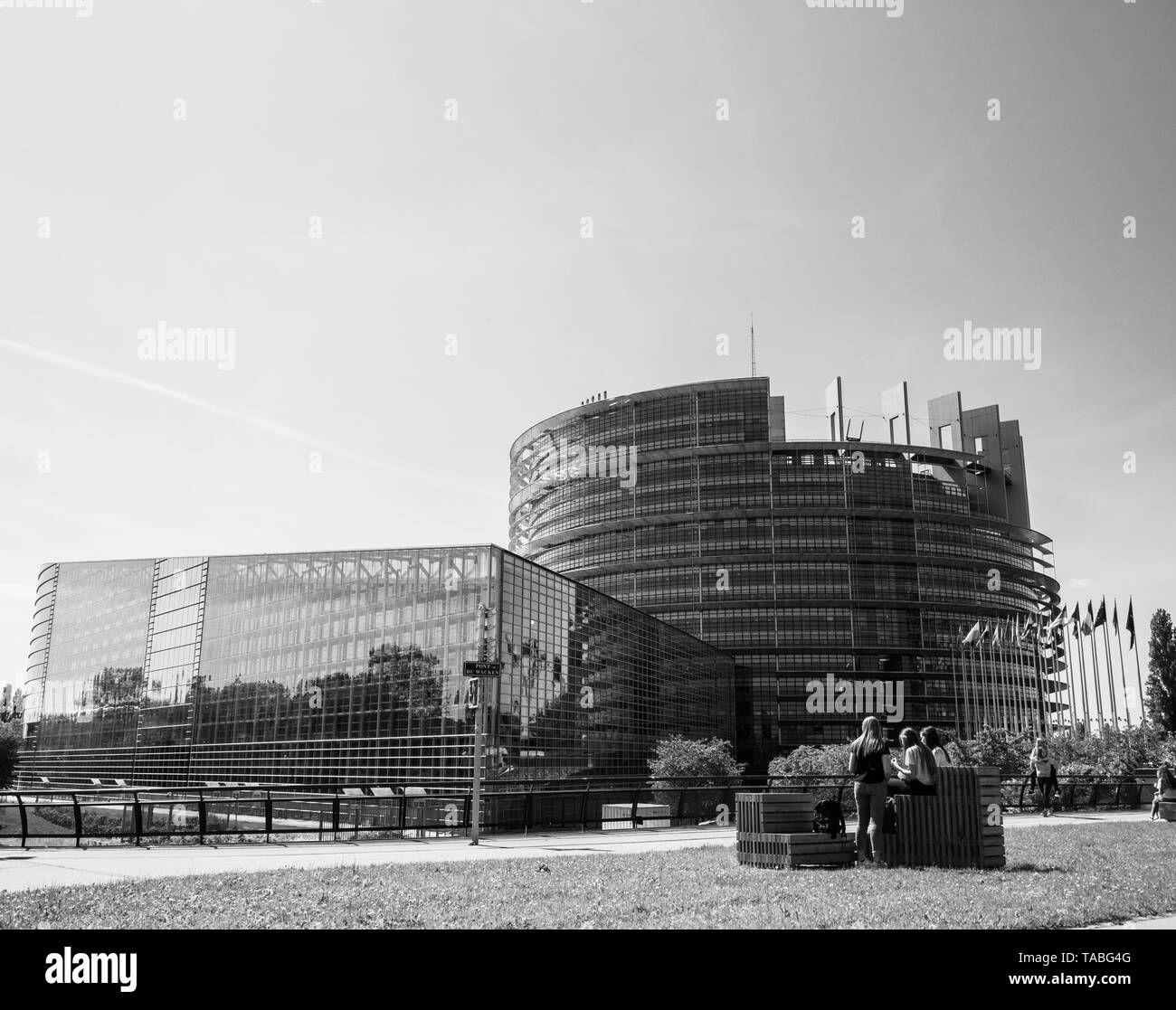 Strasbourg, France - May 23, 2019: Young carefree girls having fun reading jumping taking photos in front of European Parliament building in Strasbourg a day before the 2019 European Parliament election Stock Photo