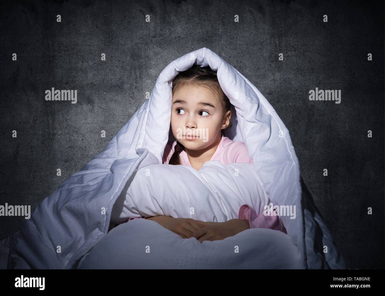 Frightened girl hiding under blanket Stock Photo Alamy