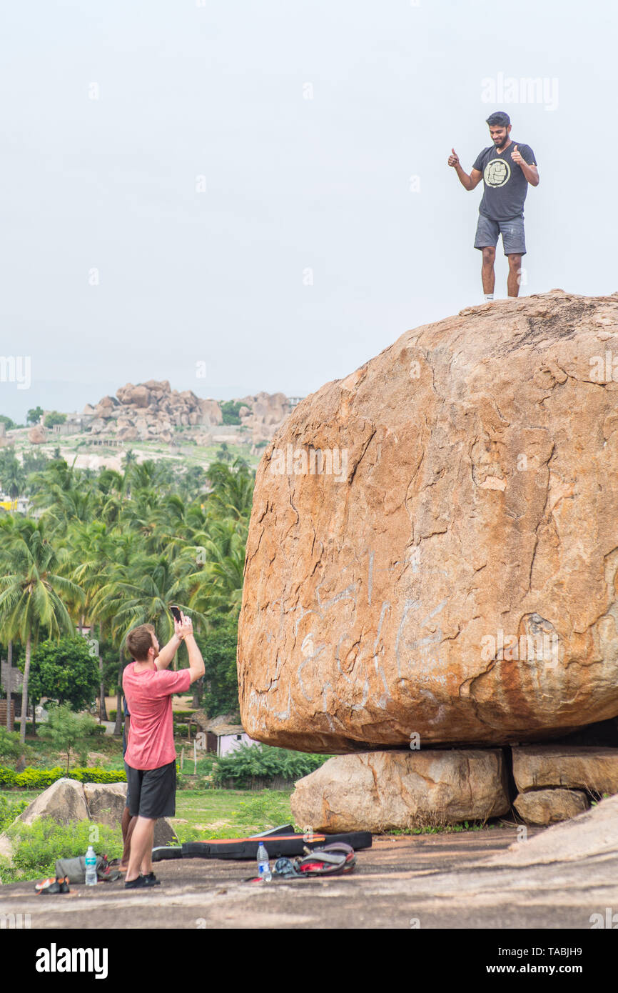 Tourists rock climbing in Hampi, India. Stock Photo