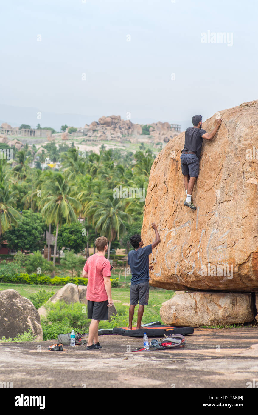 Tourists rock climbing in Hampi, India Stock Photo Alamy