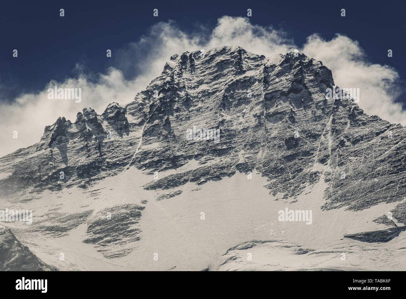 Landscape of rugged Himalayan mountain range against a deep blue sky. Stock Photo
