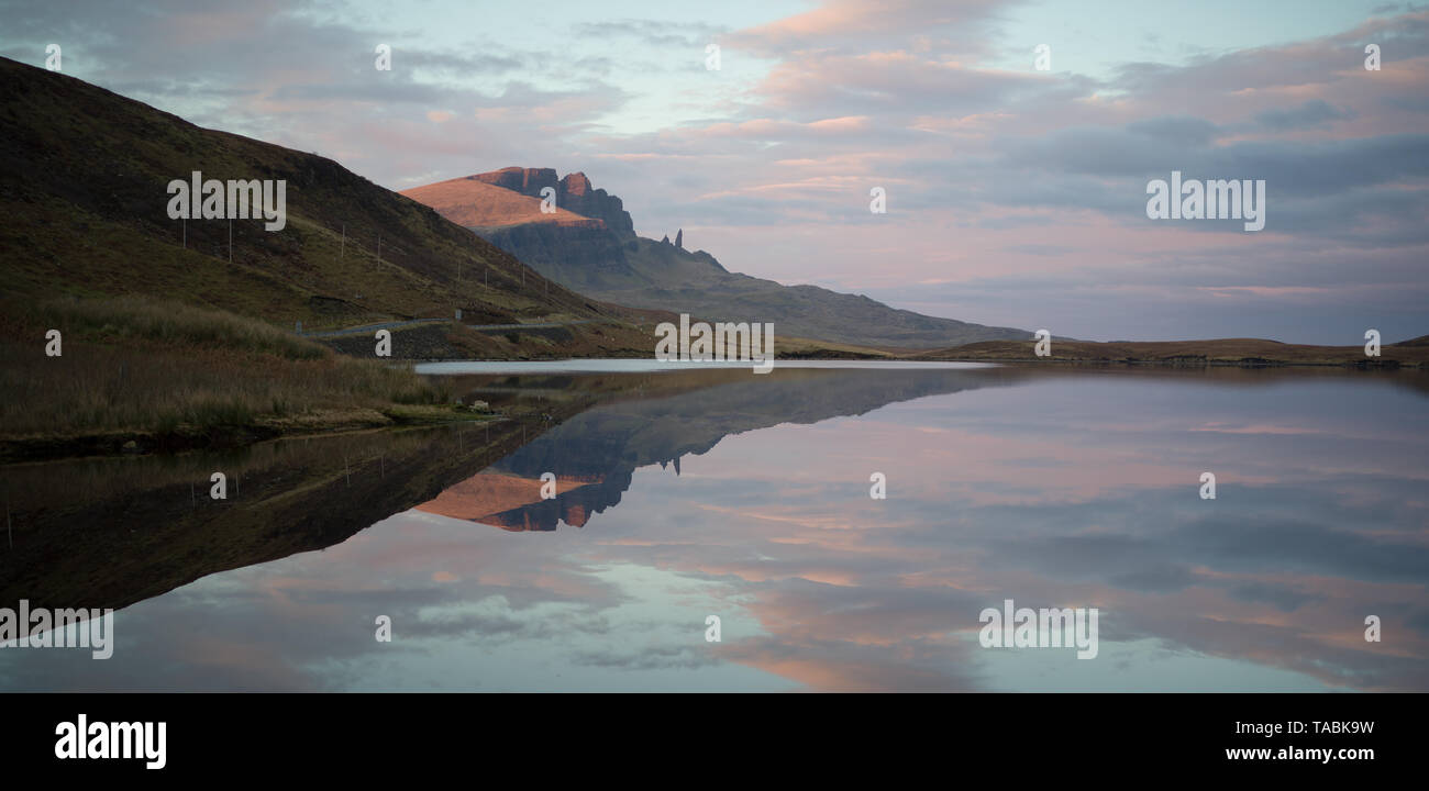 Peaceful and serene reflective view of rolling hills rising from a still lake. Stock Photo