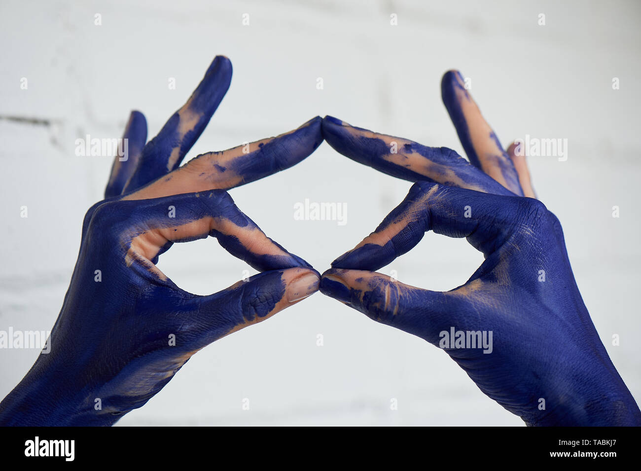 Hands in blue paint, the hands of the artist and creative person.Yoga ...