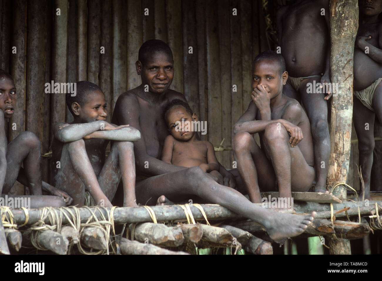 Asmat people: ethnic group living in the Papua province of Indonesia, along the Arafura Sea.  Mother and children, Village of Pirien. Photograph taken Stock Photo