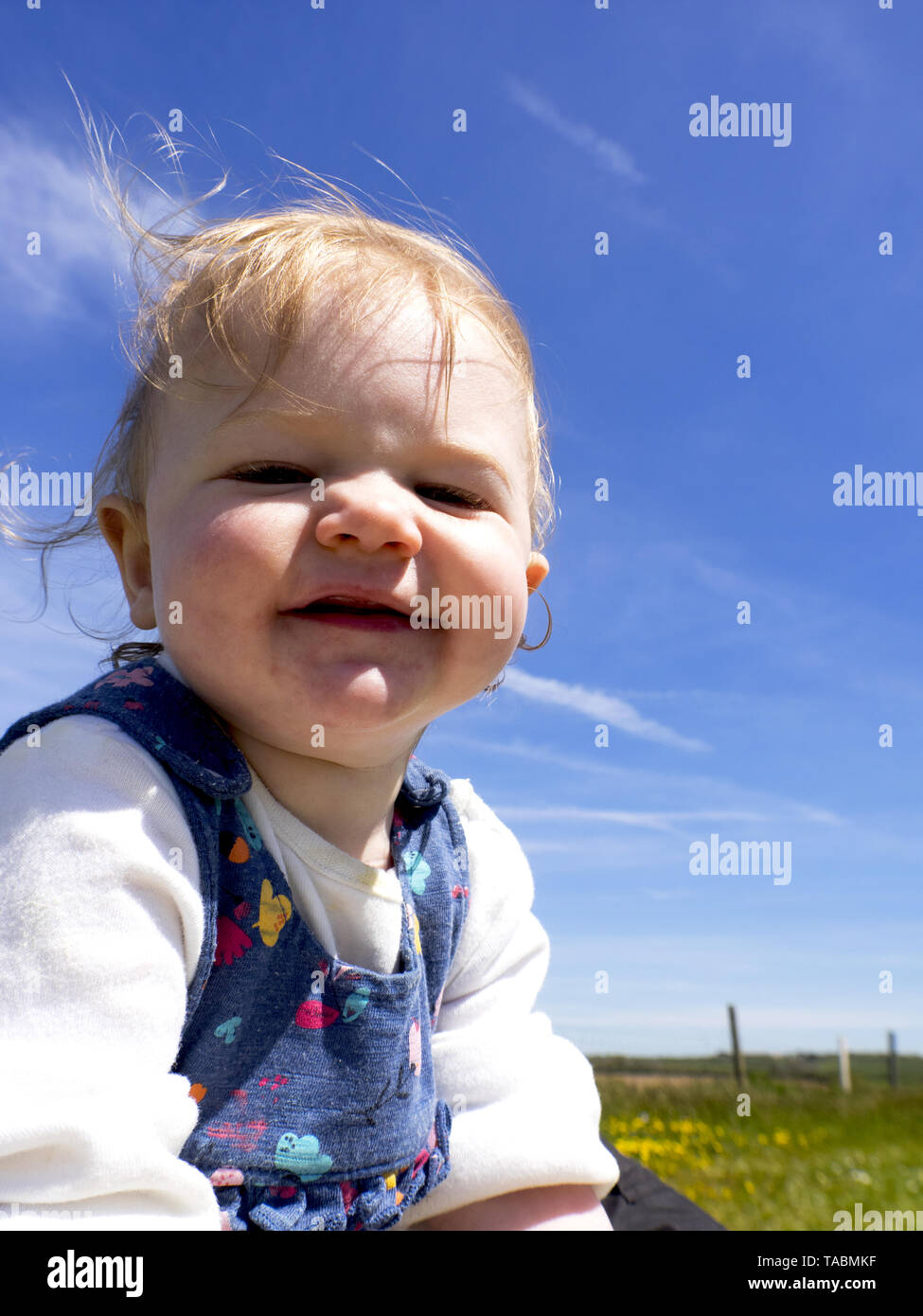 Baby girl playing outside in the summer, UK Stock Photo