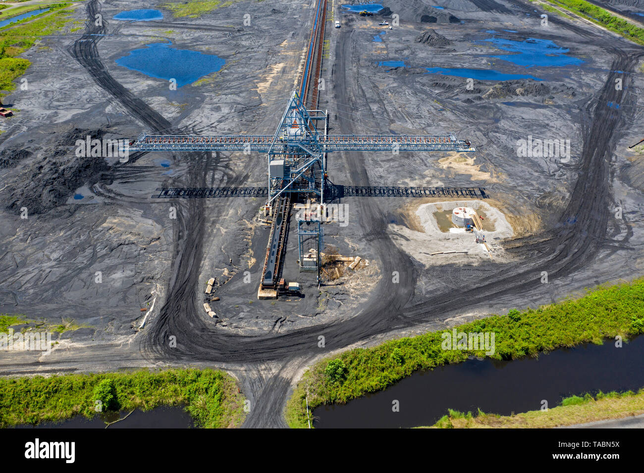 Davant, Louisiana - The United Bulk Terminals dry bulk export terminal stores coal and petcoke for export and loads it onto ships on the Mississippi R Stock Photo