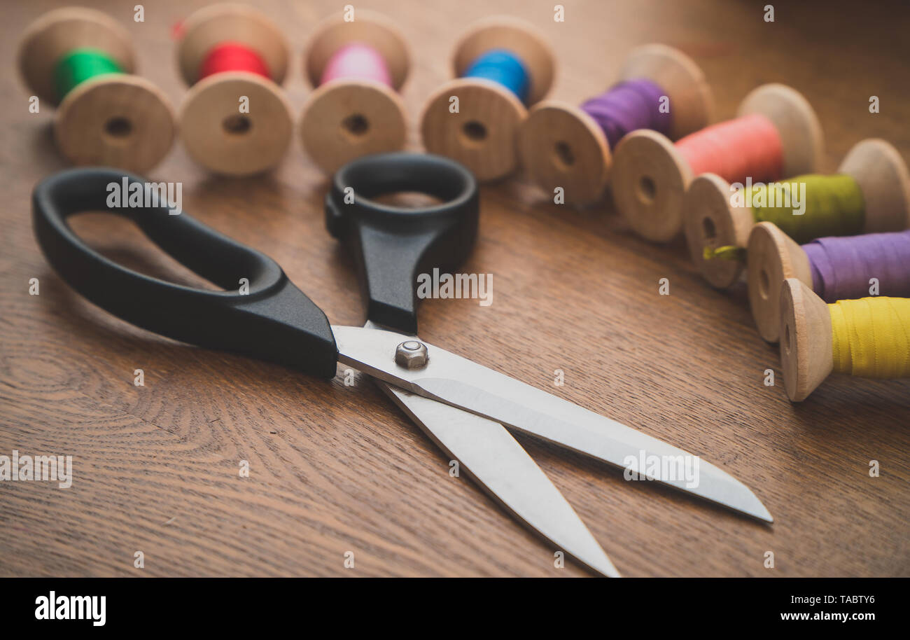 Sewing concept. Scissors and colorful thread spools. Stock Photo