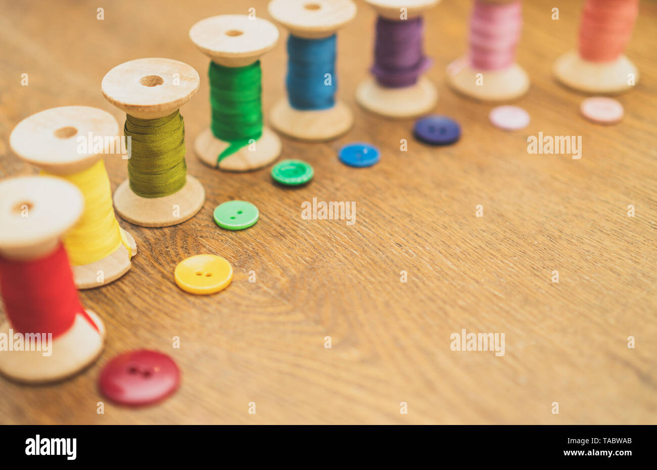 Sewing concept. Colorful buttons and thread spools Stock Photo - Alamy