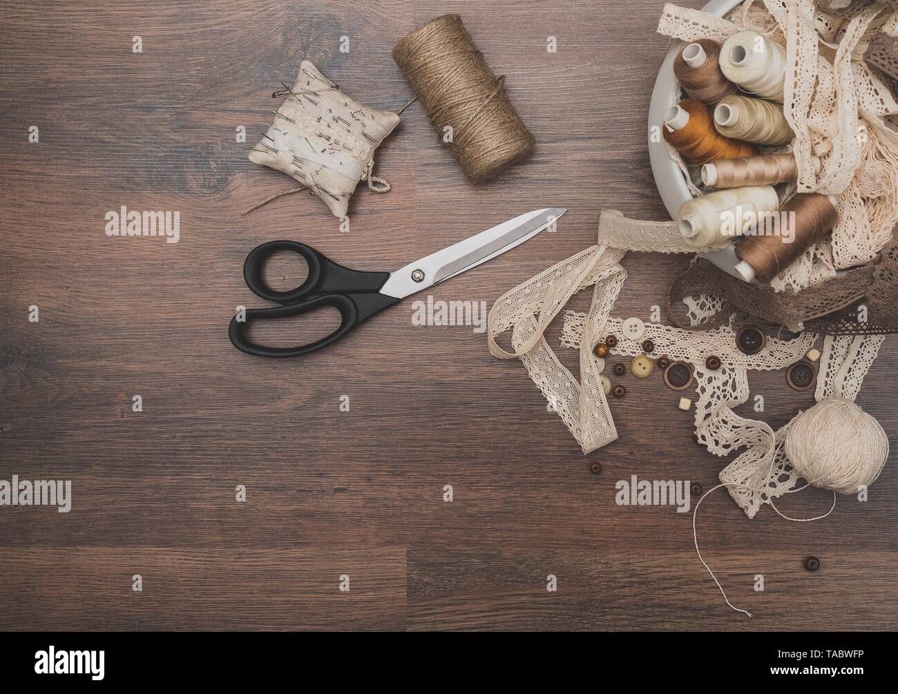 Sewing concept. Scissors, thread spools, buttons and sewing needles. Stock Photo