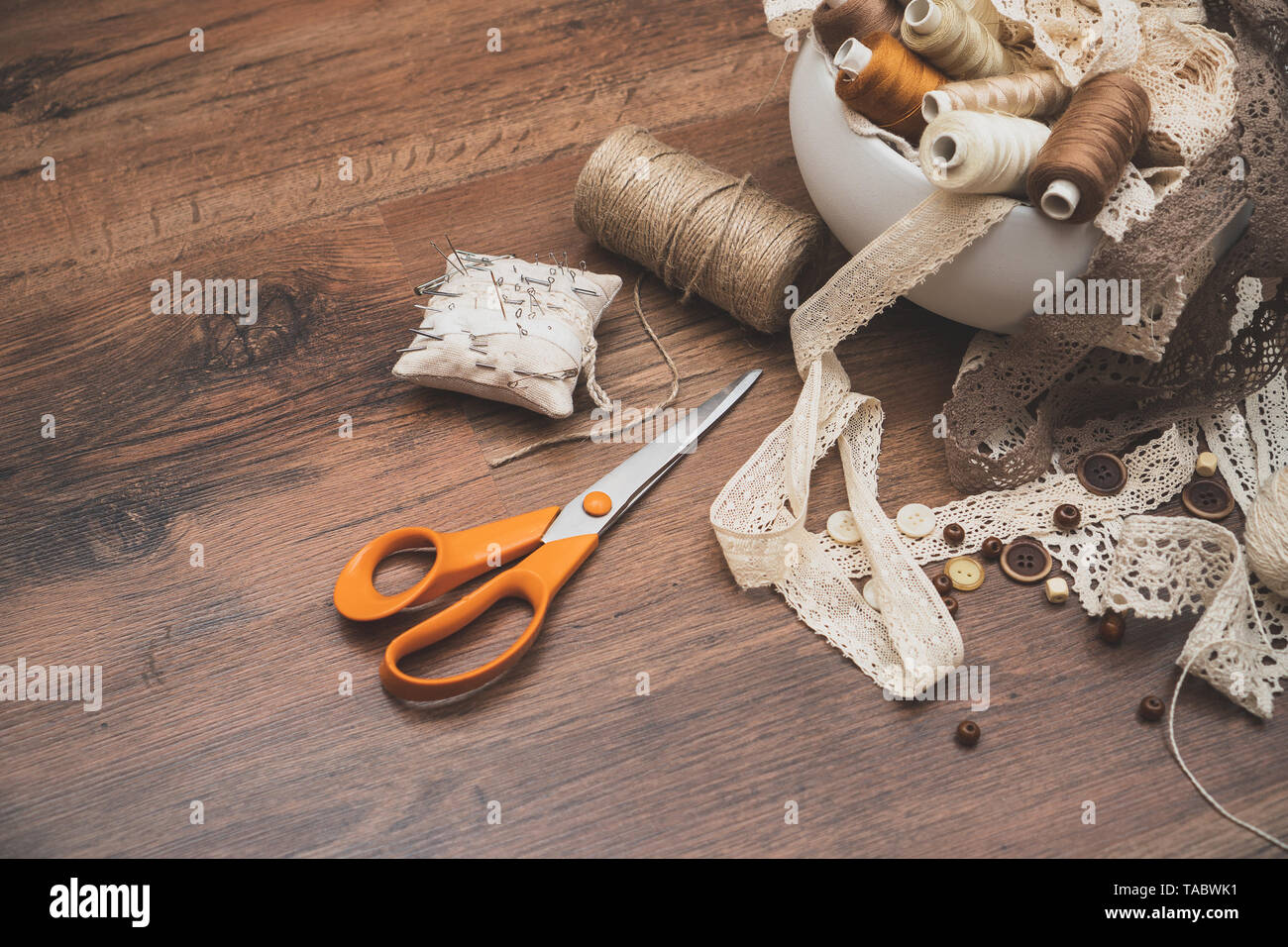 Sewing concept. Scissors, thread spools, buttons and sewing needles. Stock Photo
