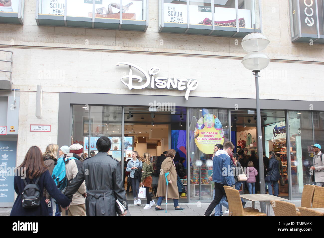 Shopping scene: People in front of Disney Store Munich, entering and passing by in the main shopping zone Neuhauser Straße. Stock Photo