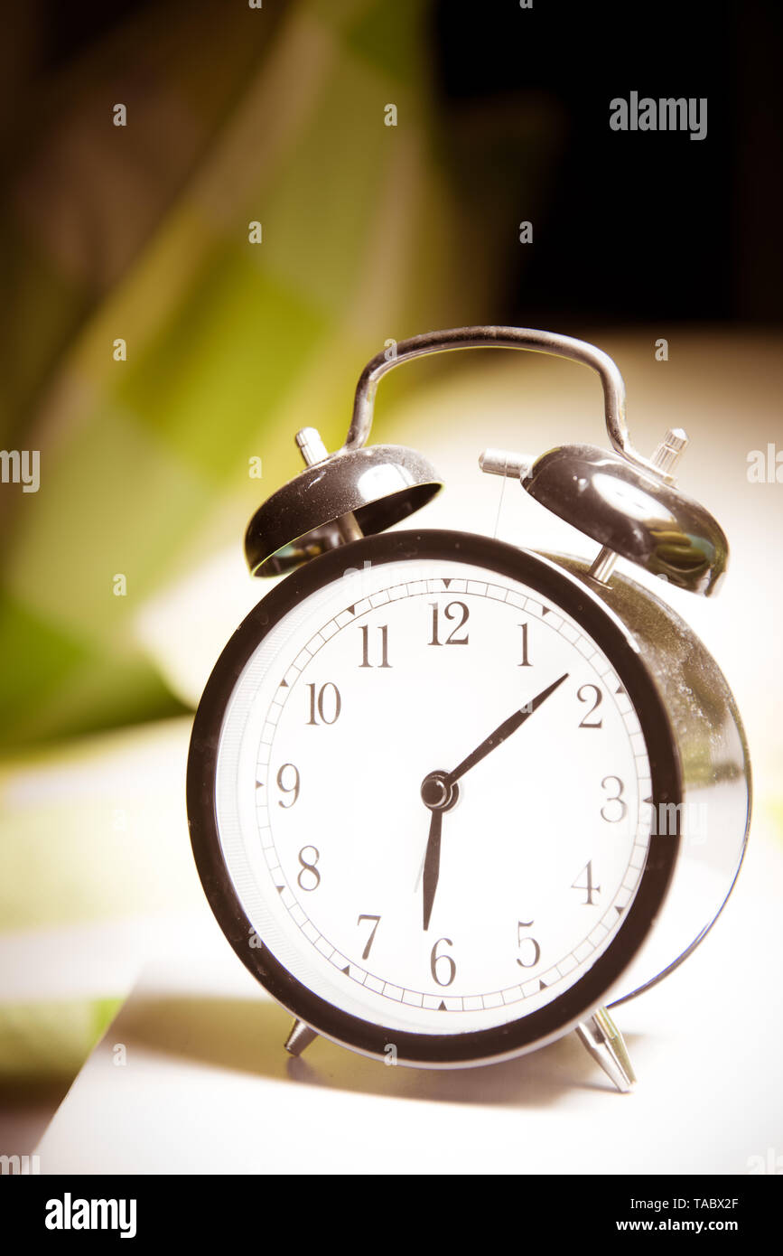 Alarm clock vintage classic alarm clock next to bed in bedroom Stock