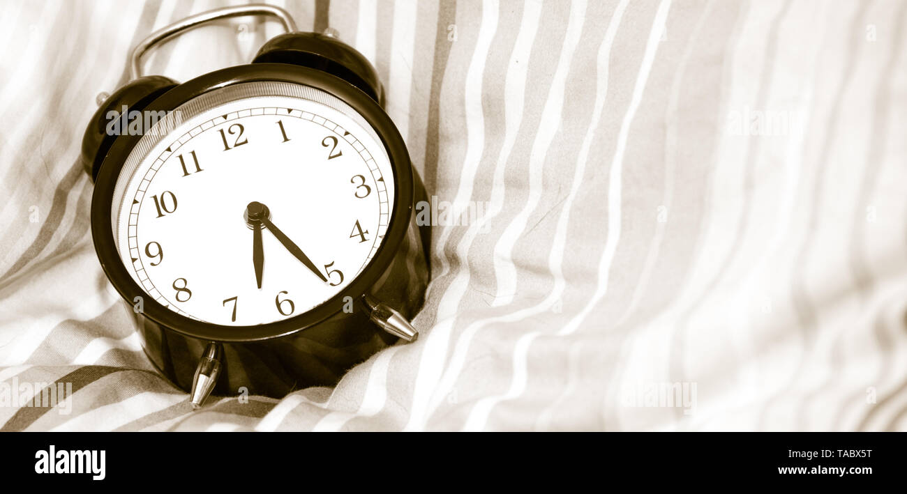 Alarm clock vintage classic alarm clock next to bed in bedroom Stock