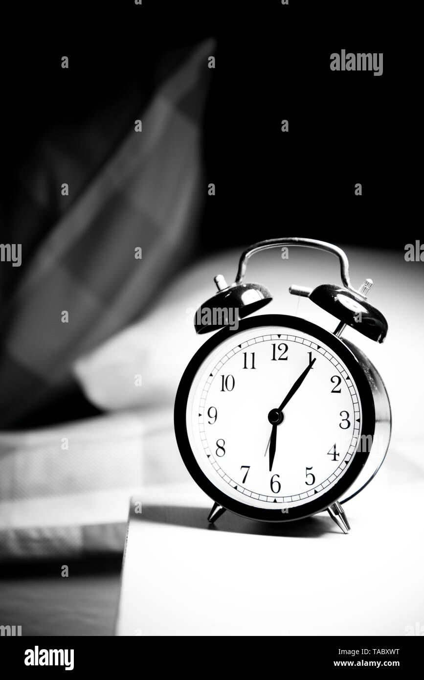 Alarm clock vintage classic alarm clock next to bed in bedroom Stock