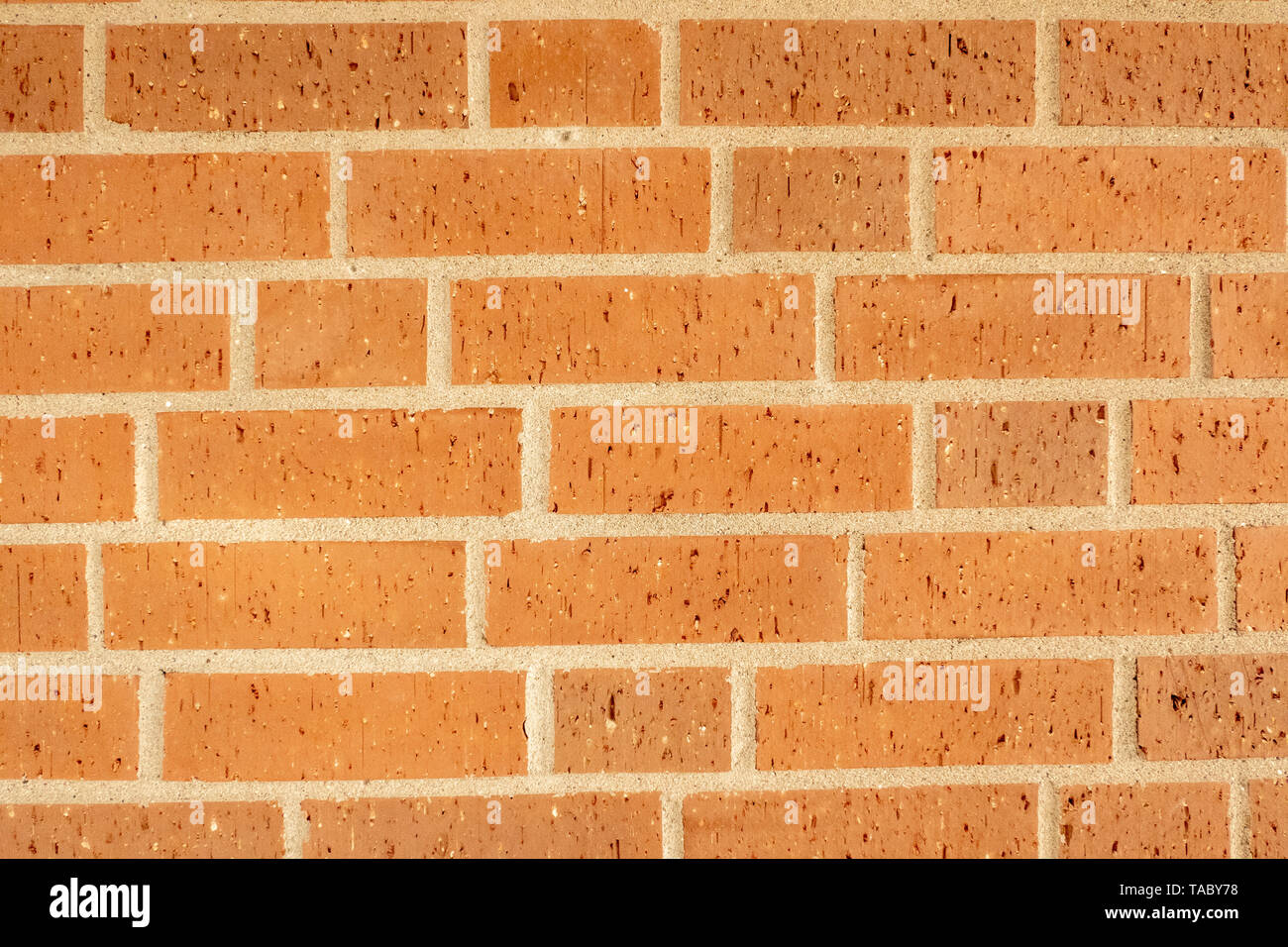 red brick wall as background with large white joints Stock Photo