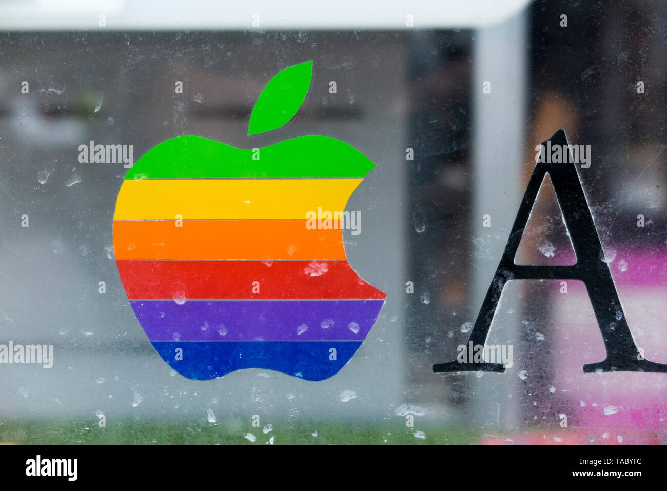 Classic rainbow bitten Apple computers logo window sticker in a computer repair / repairers shop window / Apple Reseller, in the UK. (99) Stock Photo