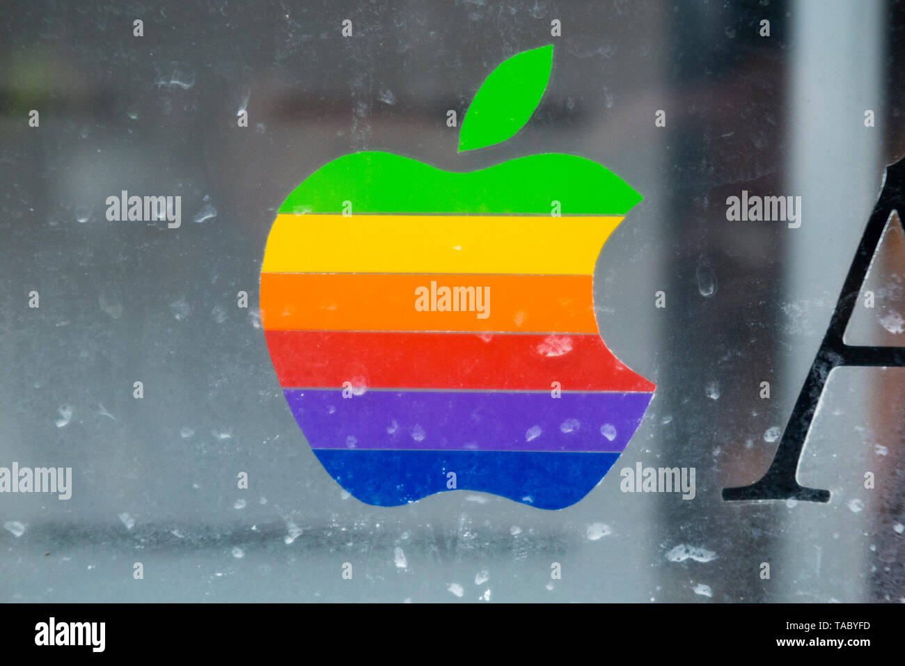 Classic Rob Janoff rainbow bitten Apple computers logo window sticker in a computer repair / repairers shop window / Apple Reseller, in the UK. (99) Stock Photo