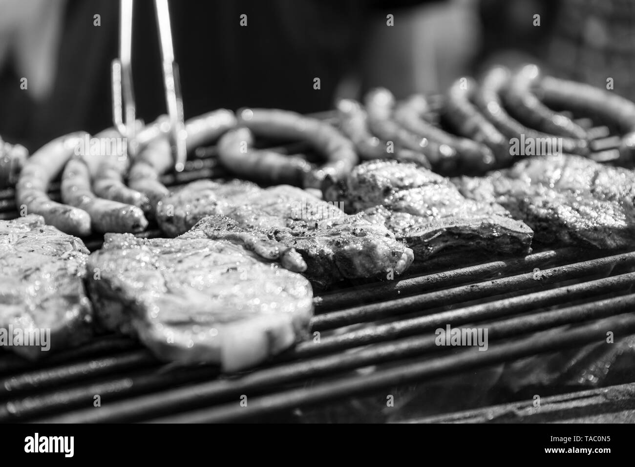 Man roasts meat, bbq. Rest on weekends. Monochrome effect. Stock Photo