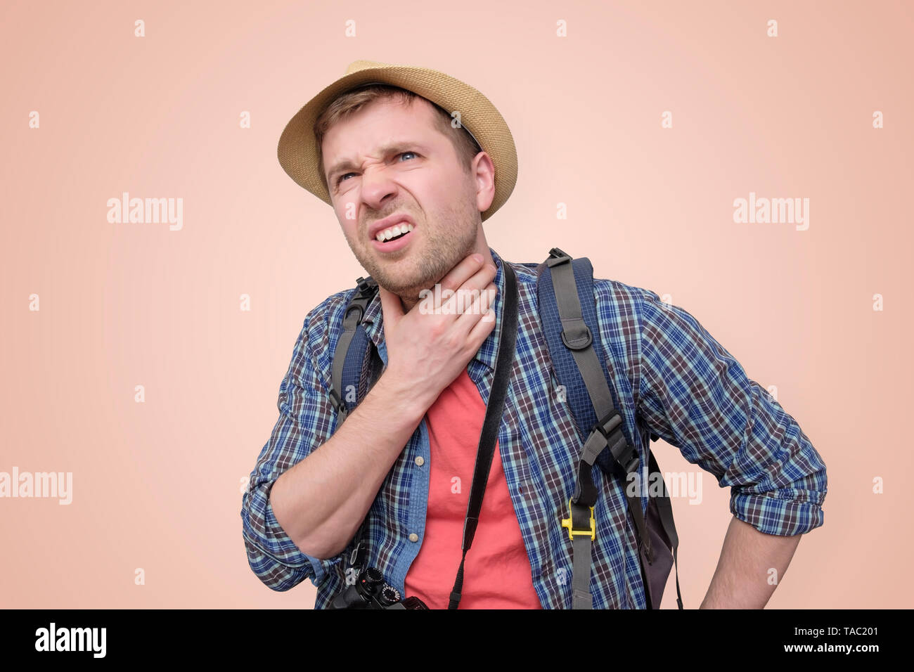 man in summer hat suffering from the pain in his throat Stock Photo