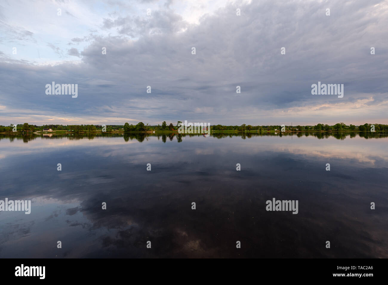riverside shore in spring with scenic trees and green pastures. calm ...